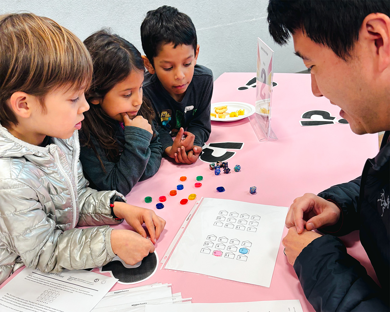 A parent helps students with a game at the Parent Faculty Club run Math Night.